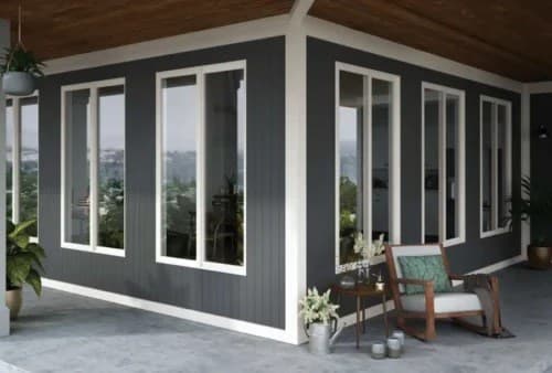 Modern home exterior with dark gray board-and-batten siding and energy-efficient white-trim windows